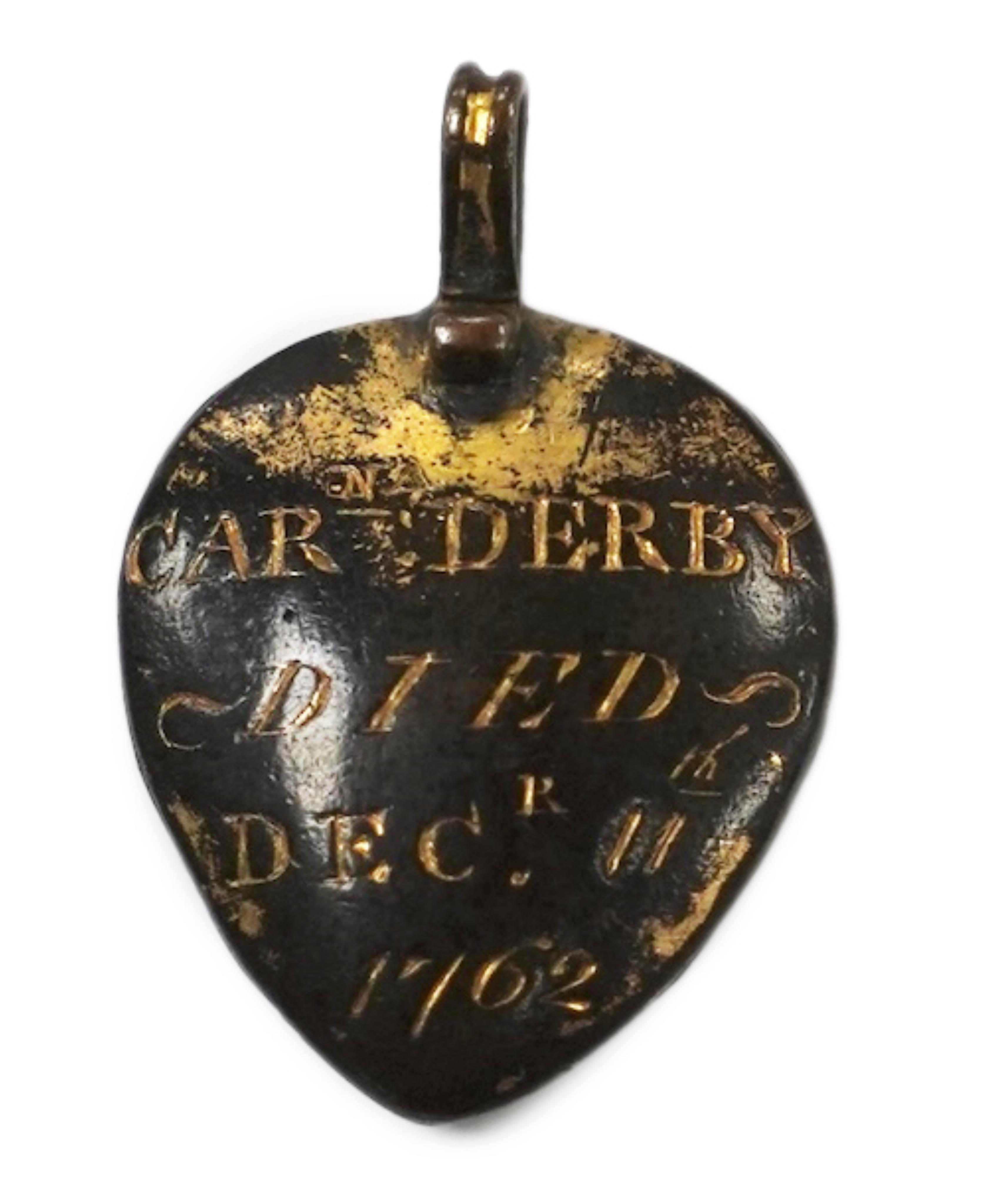 An 18th century gilt metal heart shaped mourning pendant, with engraved inscription, 'CARna DERBY DIED DEC 11th, 1762' and plaited hair beneath a glazed panel verso, 27mm.